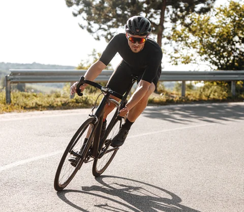 A cyclist is cycling in the middle of drive way