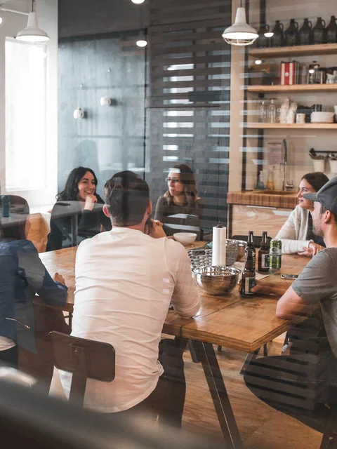 A group of people gathering in a meeting room and discussing a topic