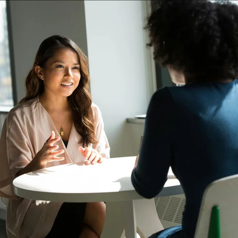 Young woman having a meeting at a table with another person