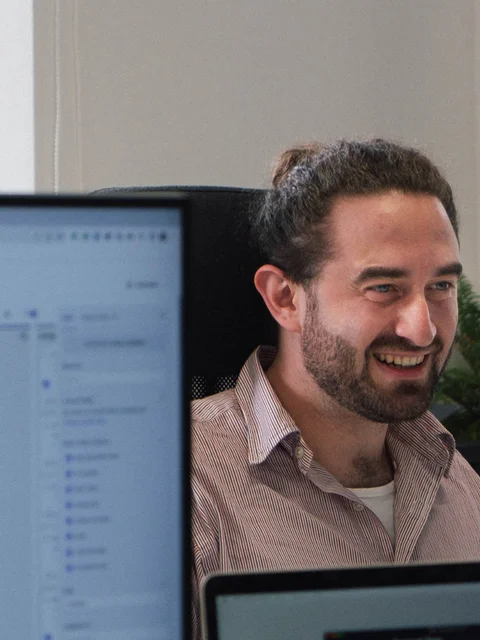 An employee at webdna, an SEO agency in Nottingham, is looking at the screen with a smile.