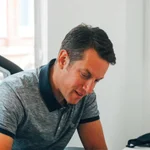 Alex Skelton, founder of webdna, is writing notes down in his office.